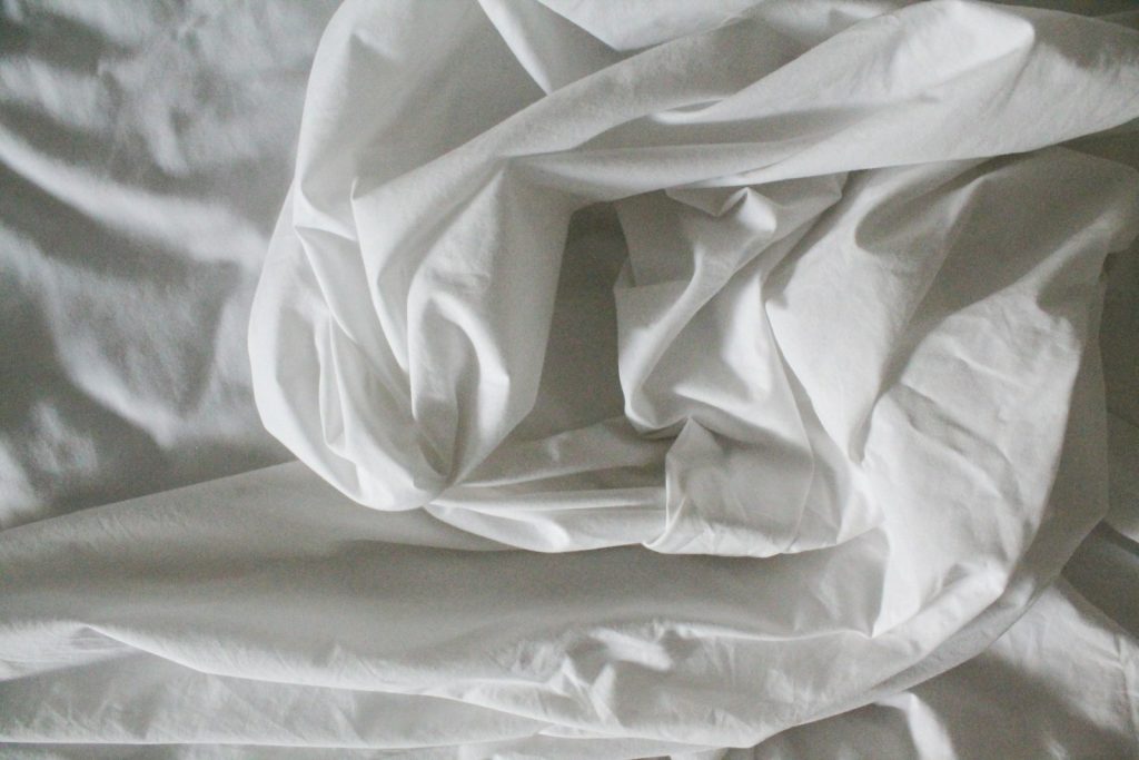 Cama con sábanas blancas — chinches en Madrid
